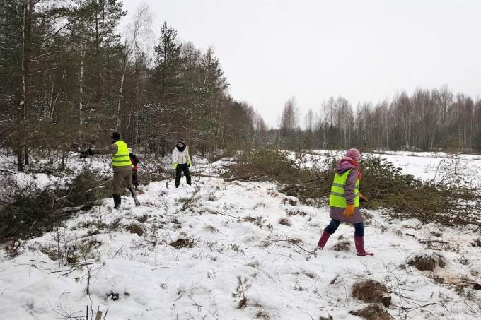 Volunteers and project staff fill a drainage ditch using biomass removed from the site in order to restore the degraded peatland. Biomass removal is often needed in order to maintain the open mire habitat. Pūsčia project site, Lithuania